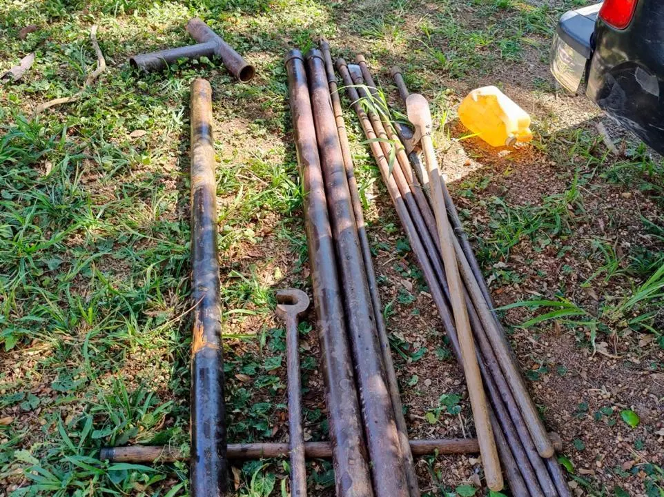 Hastes e ferramentas de sondagem organizadas no terreno antes do início do furo