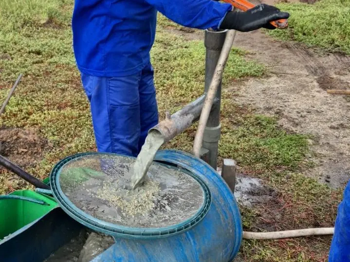 Profissional peneirando o material trazido pela água de circulação durante a sondagem