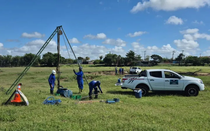 Equipe do Grupo CMG executando sondagem SPT com tripé em terreno aberto, com a caminhonete de apoio ao lado